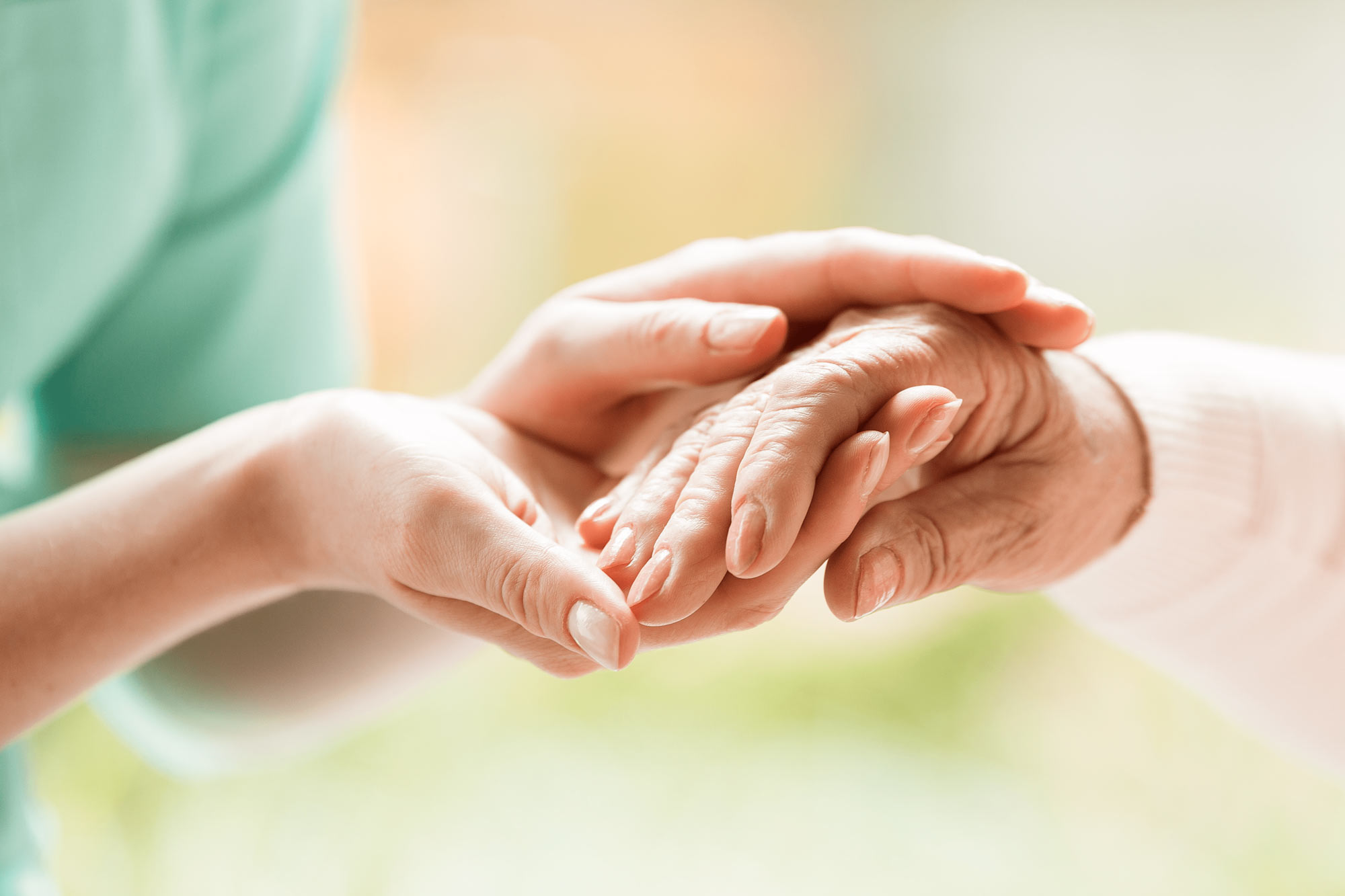 Nurse gently holding the hand of a senior person