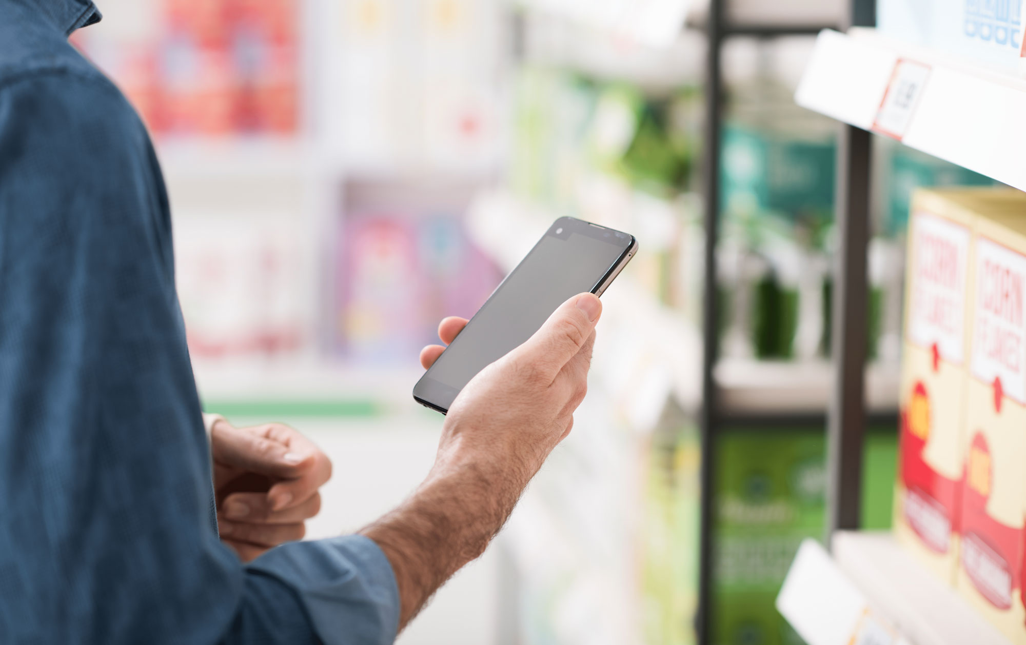 Man checking his smartphone while shopping