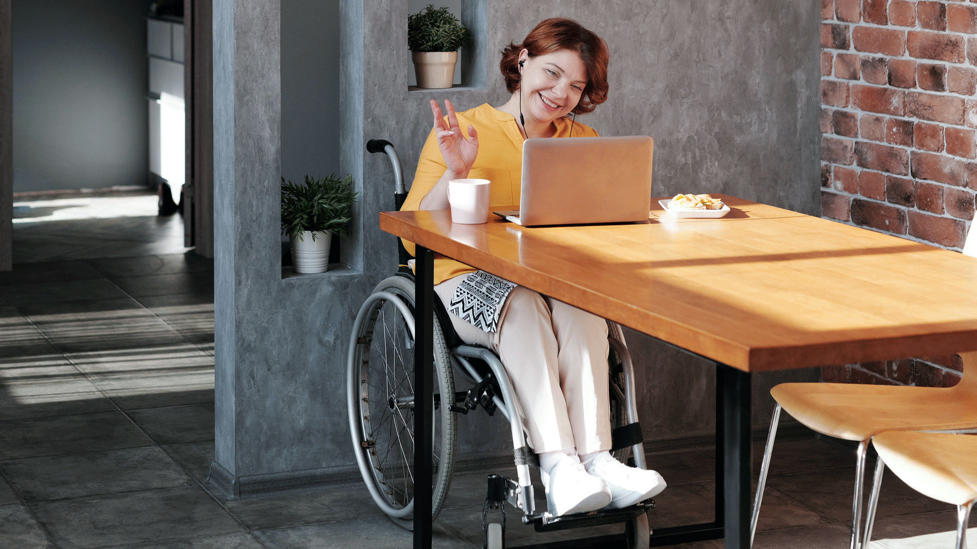 Young woman in wheelchair working on laptop