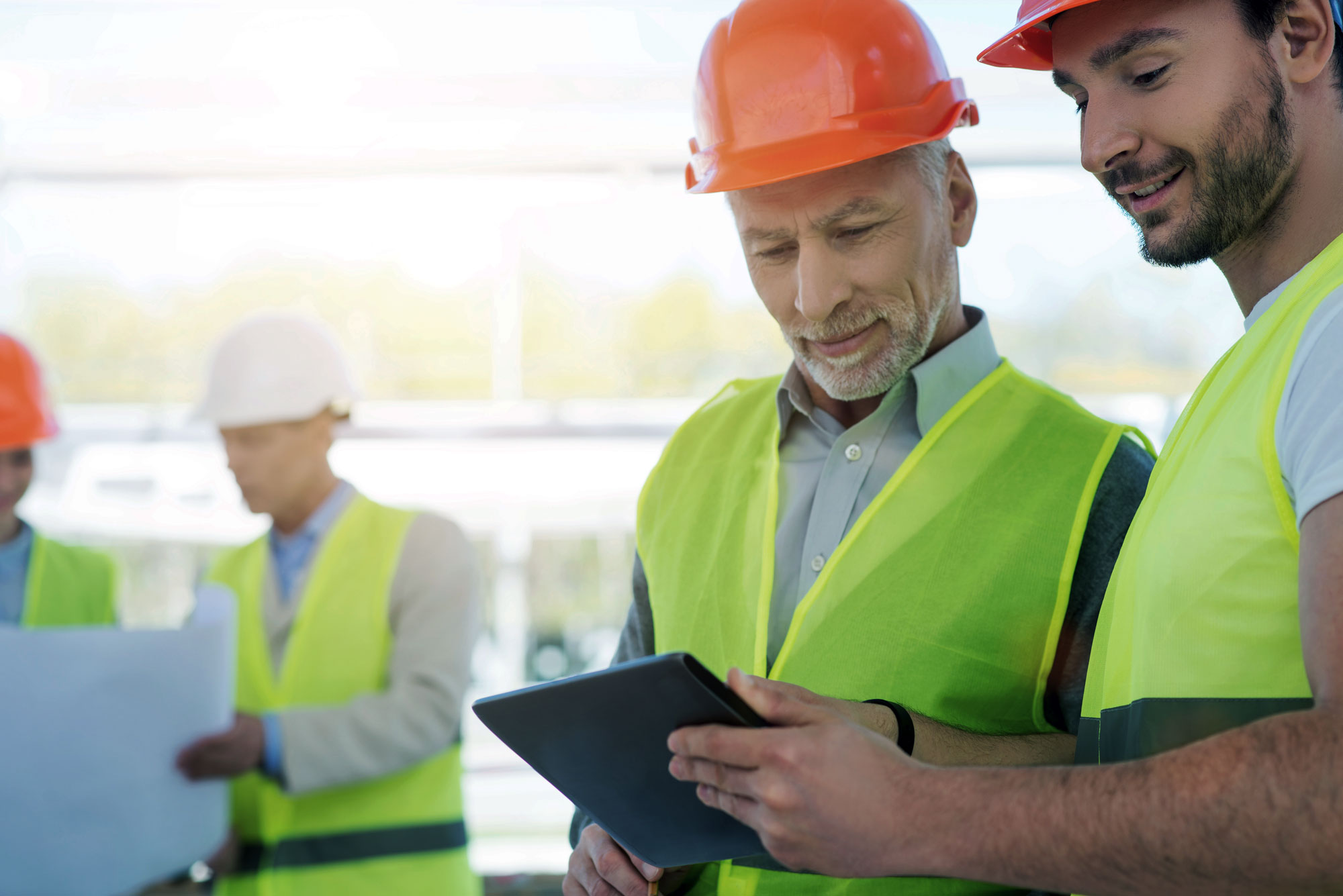 Construction workers planning together using a tablet